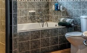 banheiro pequeno com itens e azulejos cinzas