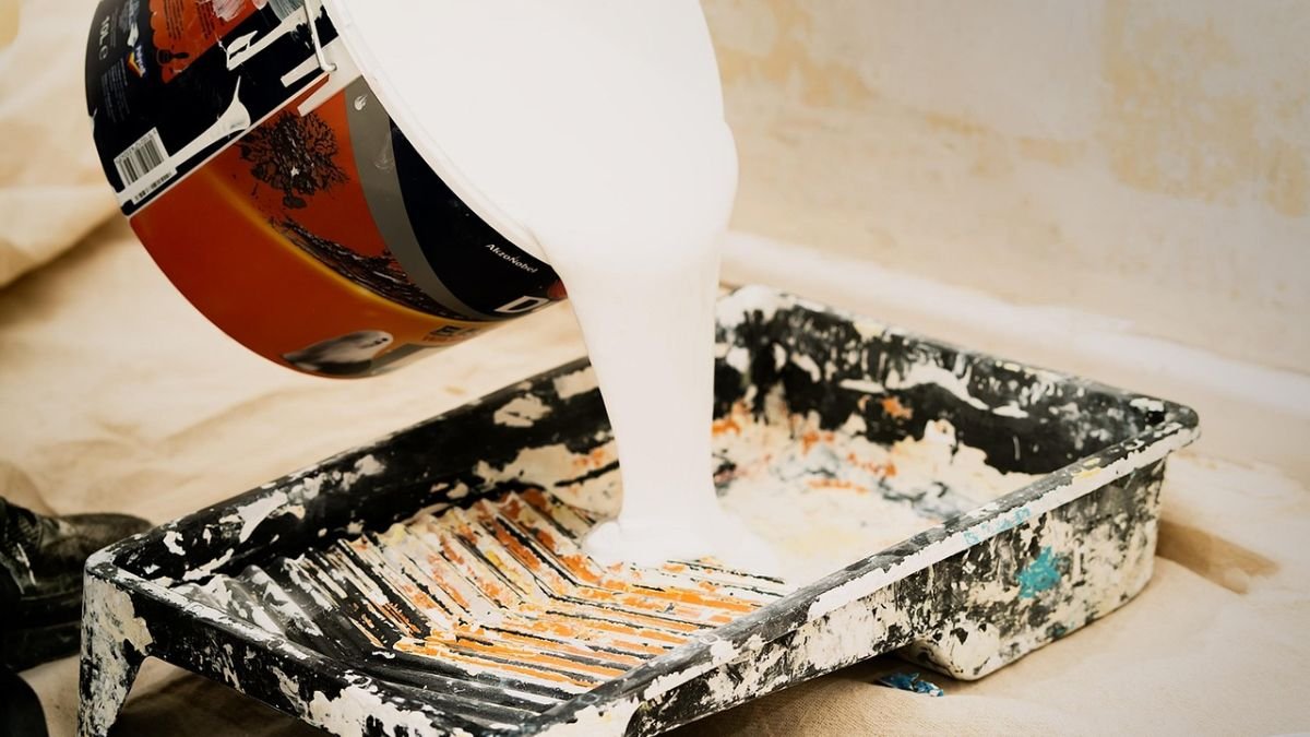 lata de tinta derramando em balde